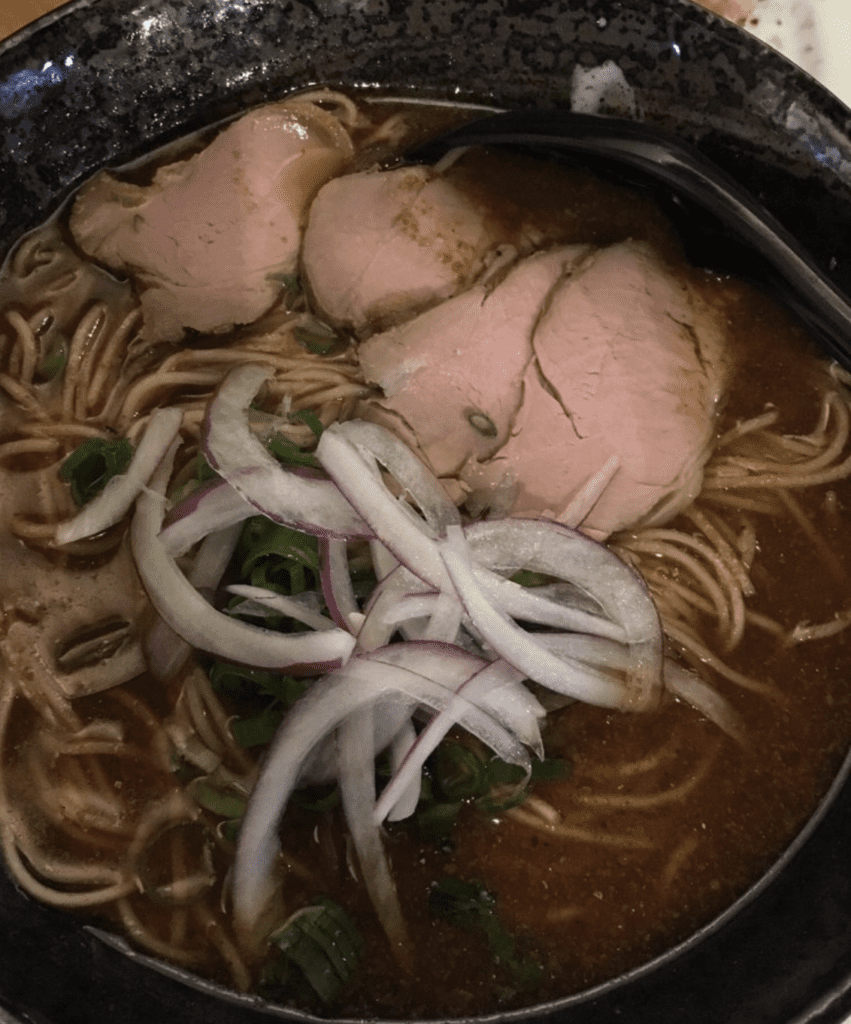 Wasabi ramen pork curry in a bowl with noodles and onions