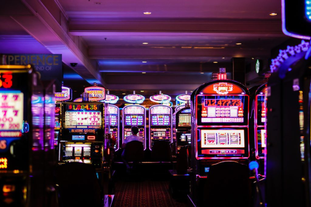 kelowna casino slot machines with neon lights in a dark casino room