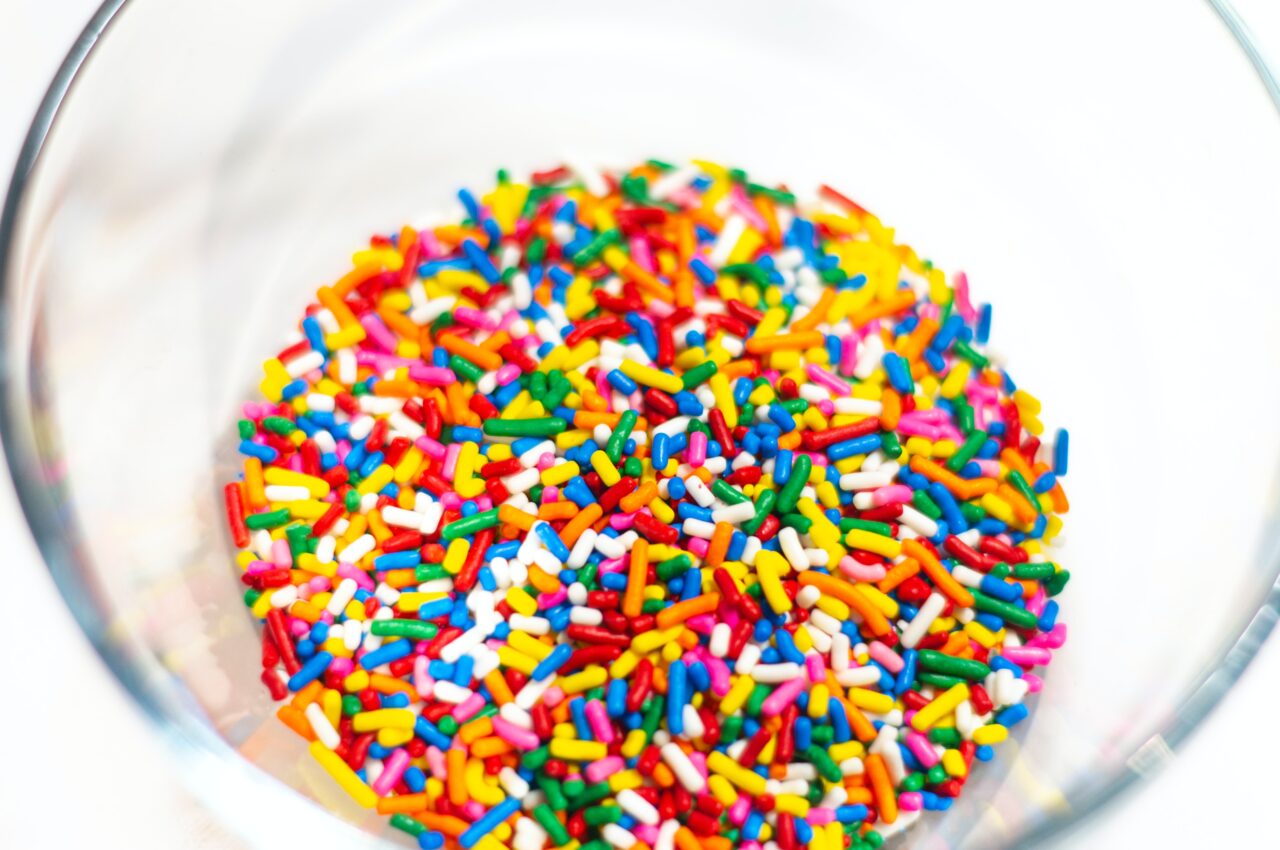 multi-coloured ice cream sprinkles in a clear glass bowl