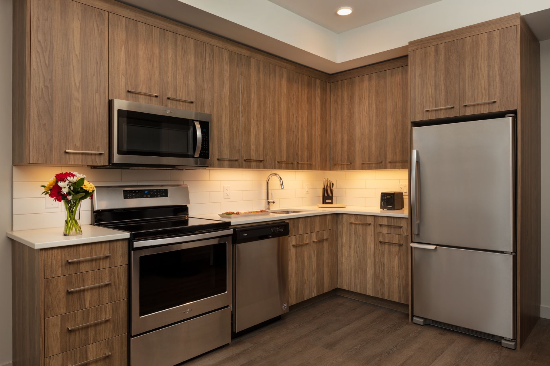 the kitchen with stainless steel appliances and subway tile backsplash in The Shores one bedroom suite