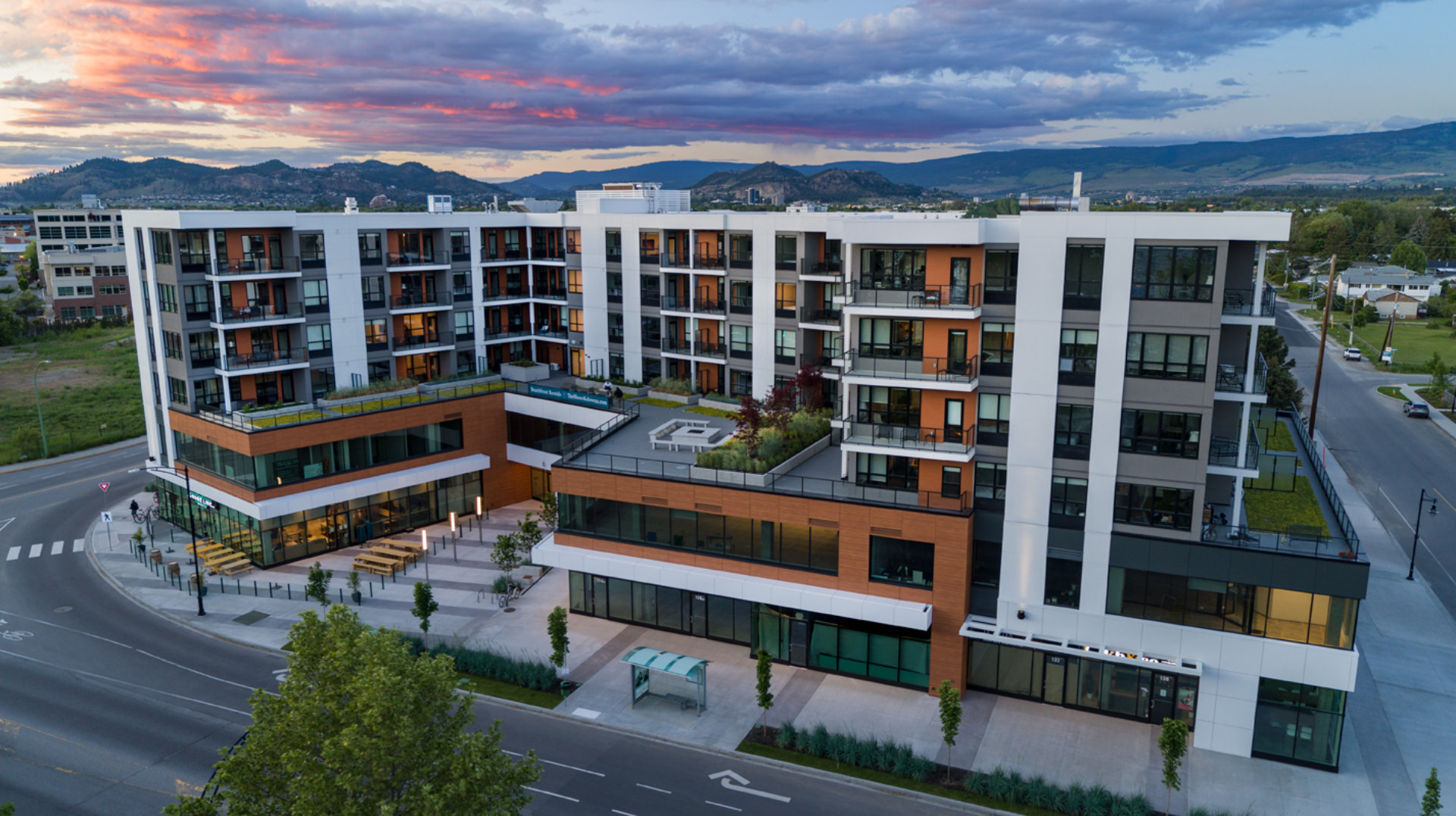 The Shore Hotel Exterior with sunset above Kelowna mountains