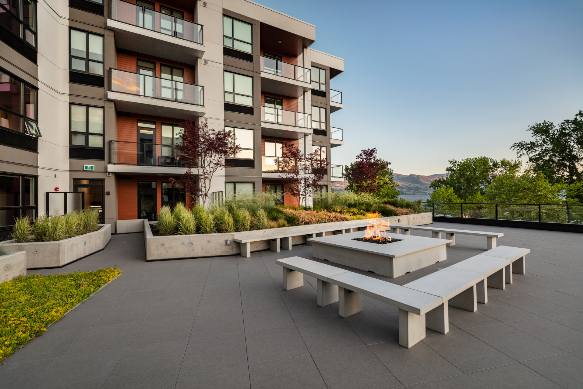 Outdoor Terrace at The Shore Hotel in Kelowna showing a fire pit with lit fire and seating around it