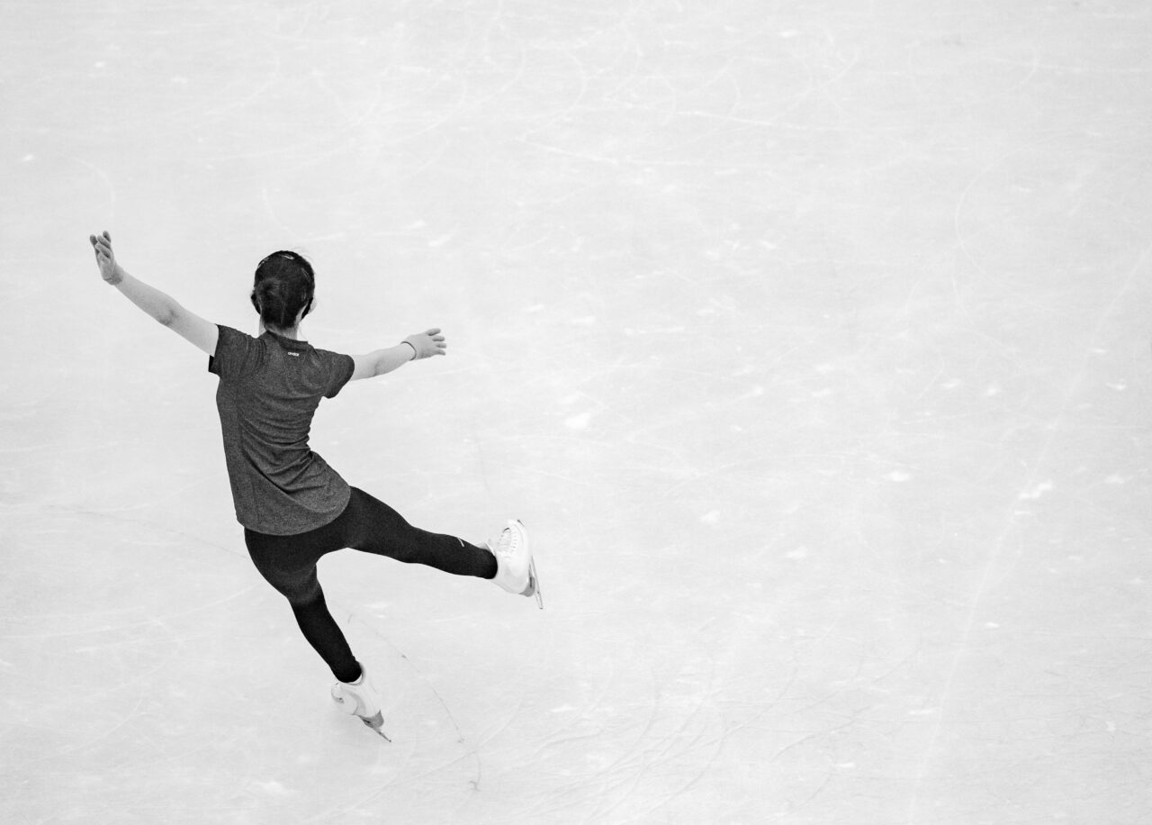 a figure skater in black and white, view from above while she performs