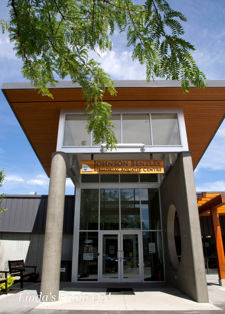 the Johnson Bentley Memorial Aquatic Centre exterior entryway, showing the front doors and sign above the door