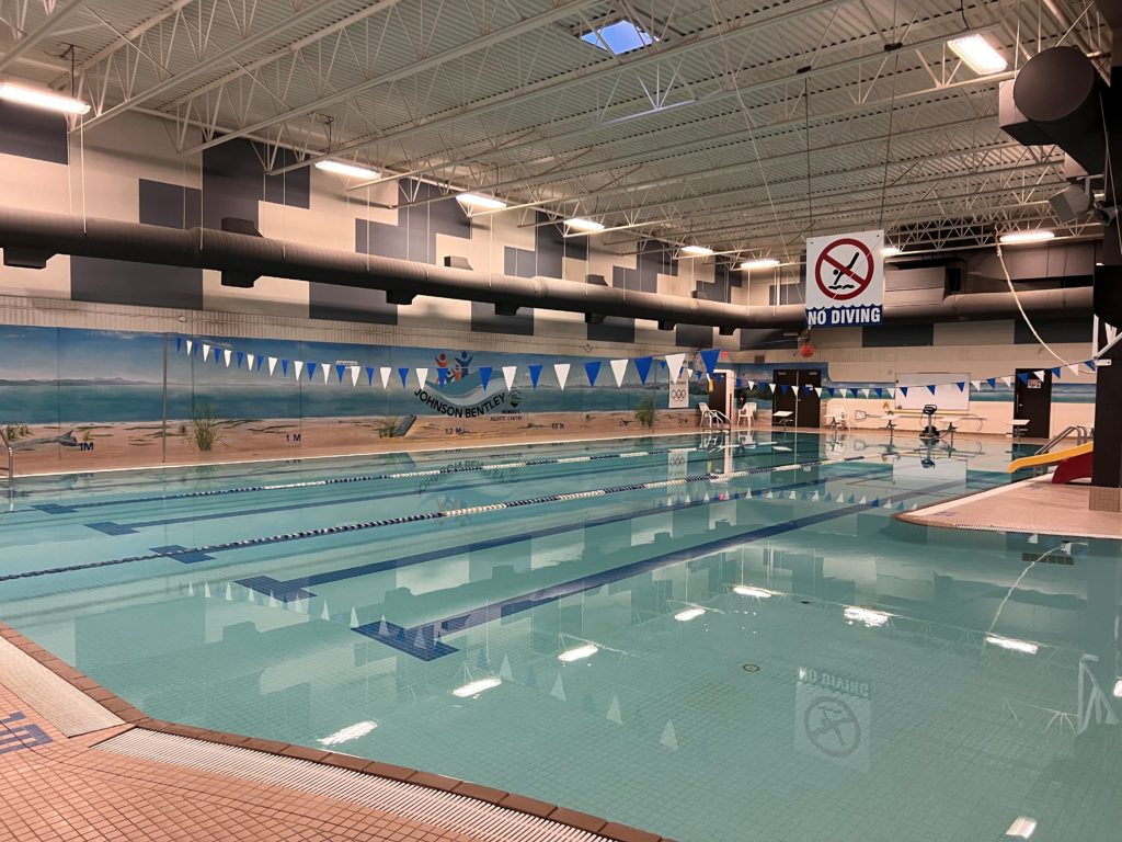 an interior view of the pools at Johnson Bentley Memorial Aquatic Centre, with a no-diving sign and calm water