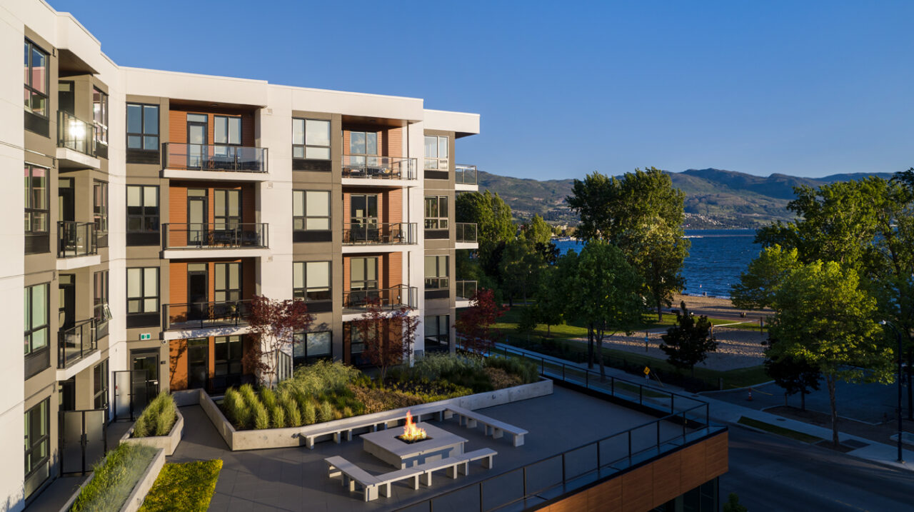 the shore kelowna, a hotel-apartment complex, shown here with gyro beach and okanagan lake in the background