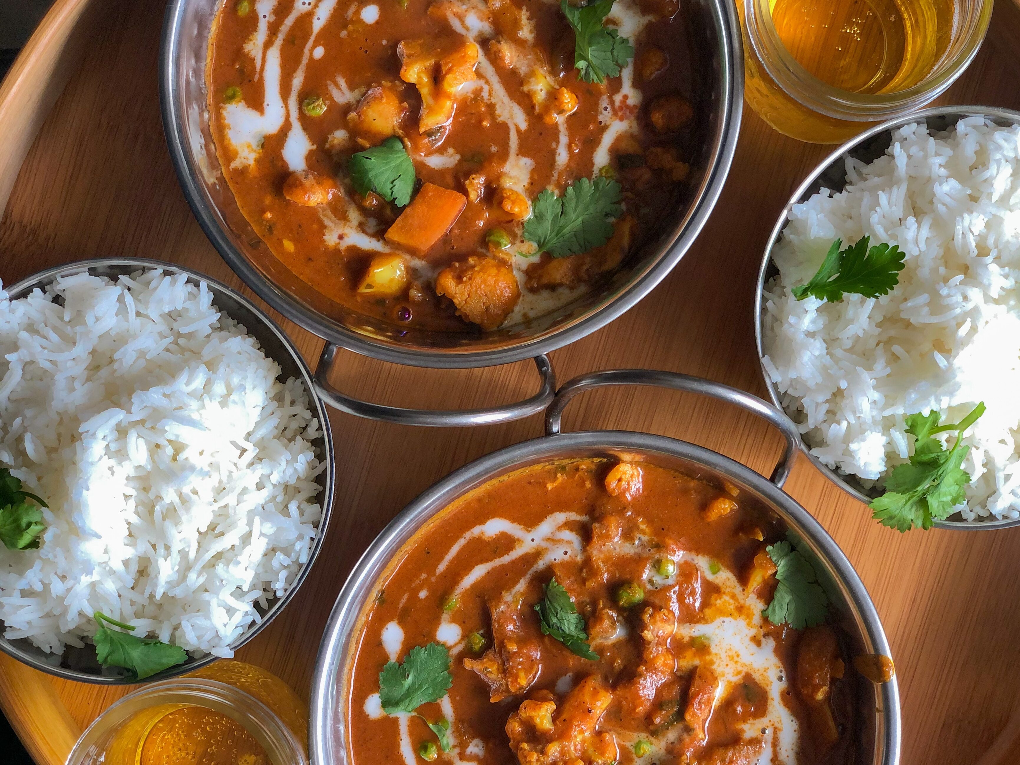 a top-down view of two butter chicken dishes with rice served at a kelowna east indian restaurant