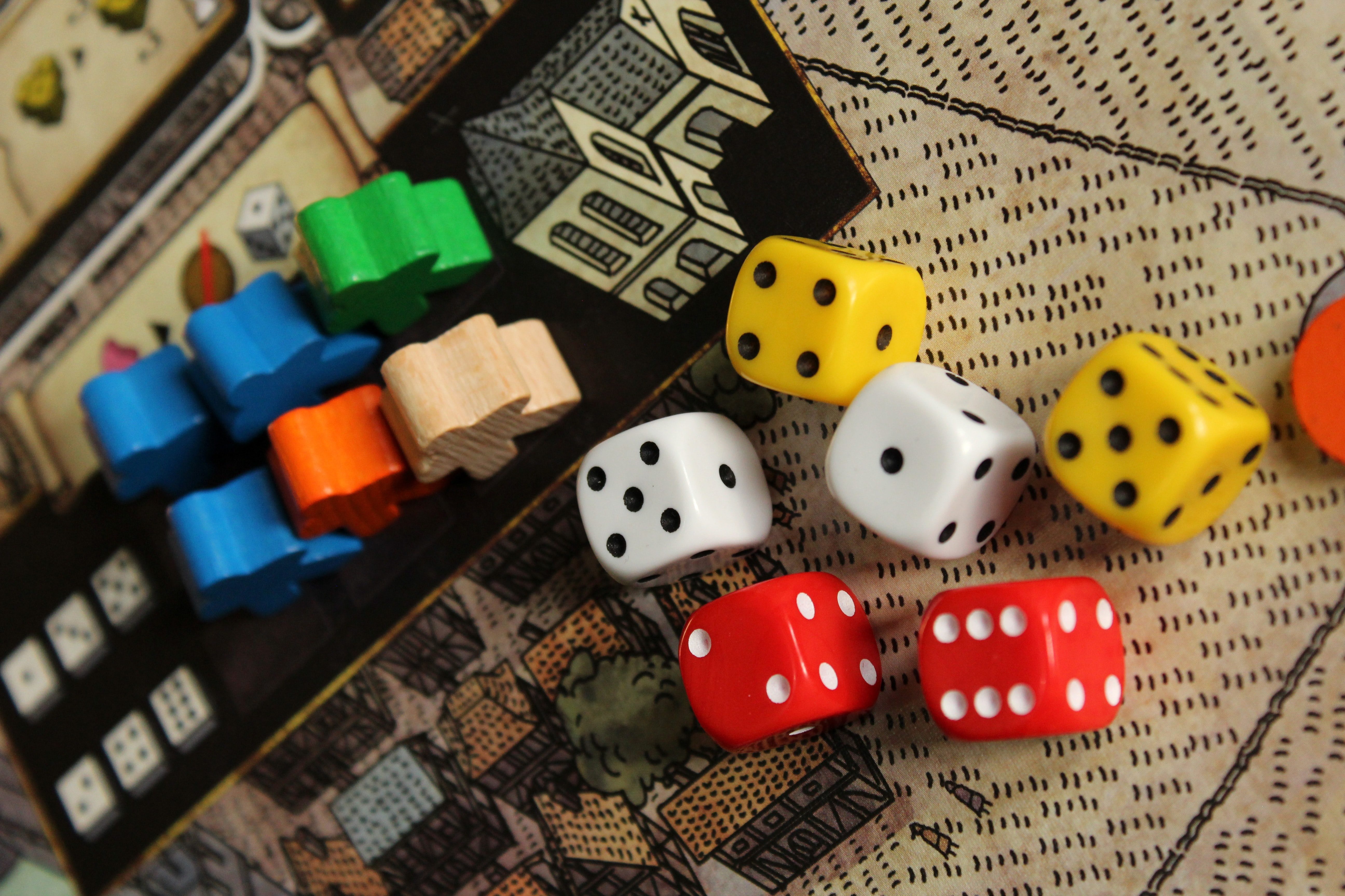 board game pieces and dice on a playing board, highlighting rainy day indoor activities in Kelowna