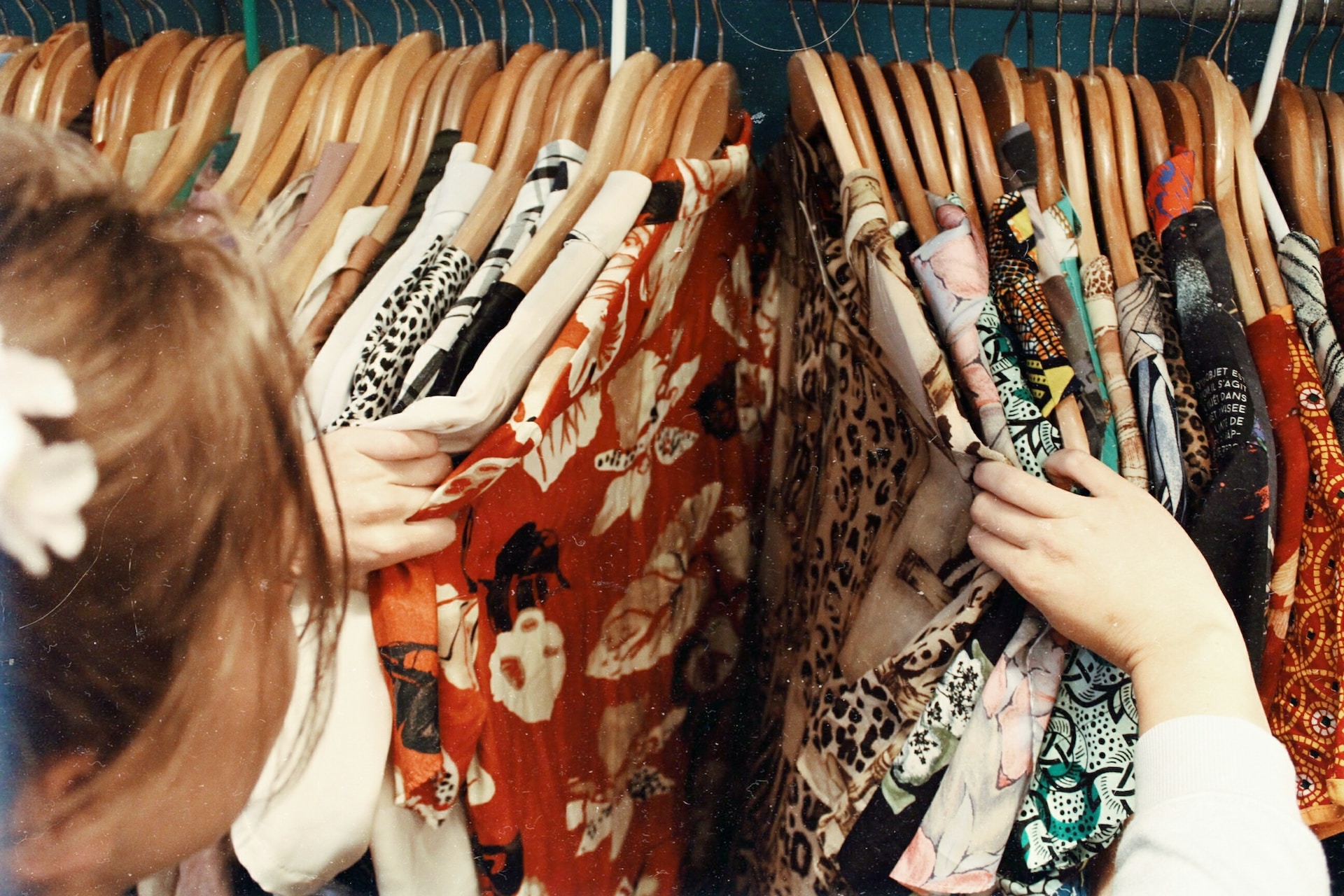 a woman browsing racks of second-hand clothing at thrift stores in kelowna